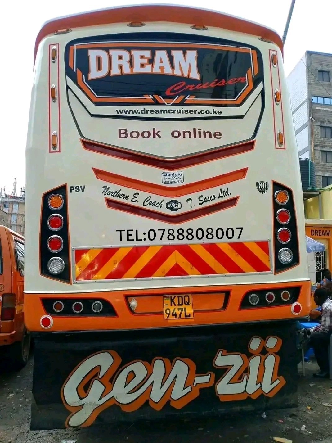Rear view of a white and orange Dream Cruiser tour bus with Gen-zii branding, contact details, and book online information displayed